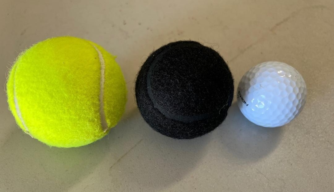 Size comparison of a regular tennis ball, a precut tennis ball for school chairs, and a golf ball